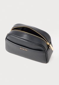 Black leather Michael Kors pouch with gold zipper partially open and front pocket, set against a plain light background.