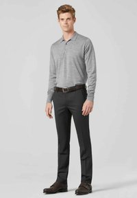 Grau langärmliges Poloshirt mit Kragen, kombiniert mit dunklen Hosen und braunen gemusterten Schuhen, ausgestattet mit einem Gürtel und einem klassischen Schnitt.