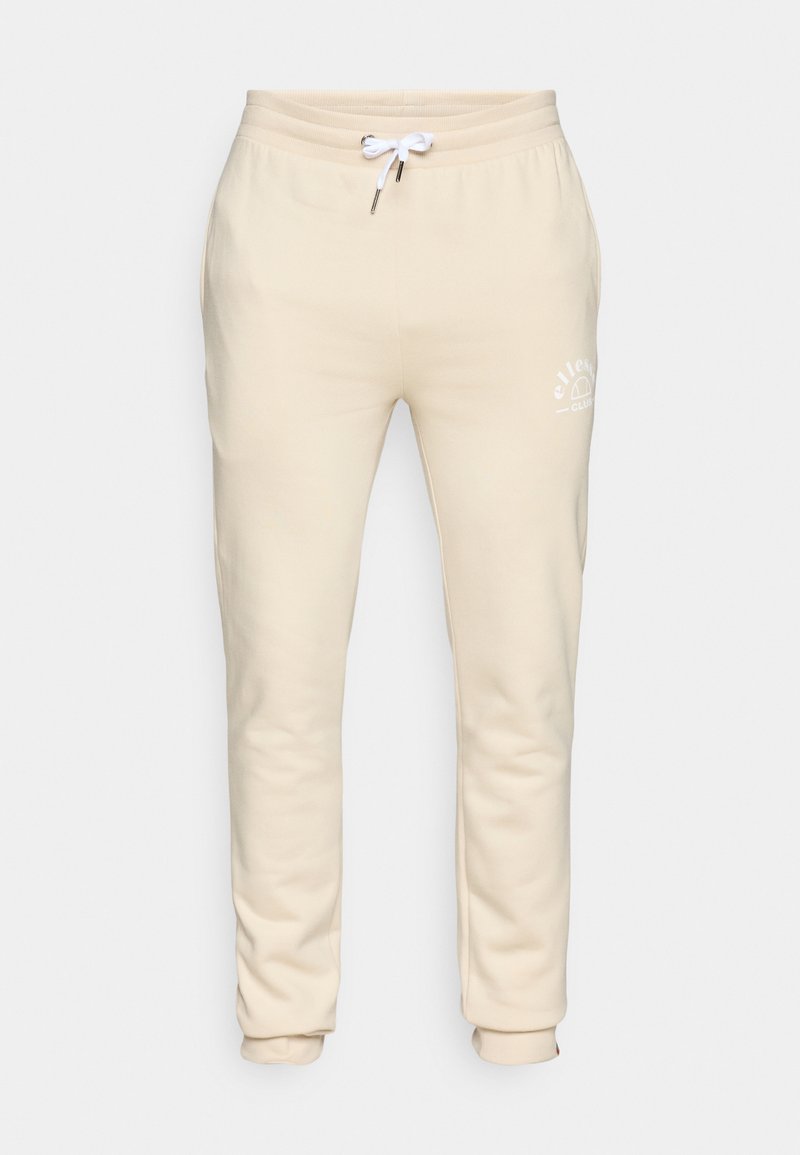 Pantalones de chándal beige hechos de una tela suave, con cintura ajustable por cordón y puños elásticos, y un pequeño logo blanco en la pierna izquierda.