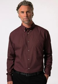 Camicia button-up bordeaux con un motivo sottile, maniche lunghe, taschino sul petto e colletto standard, abbinata a una cintura nera.