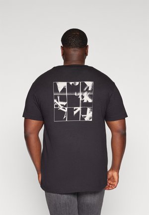 T-shirt in cotone nero con maniche corte, caratterizzata da una stampa grafica bianca sul retro disposta a griglia con elementi astratti.