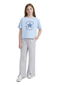 Ανοιχτό μπλε βαμβακερό μπλουζάκι με γραφικό "Converse All Star", συνδυασμένο με γκρίζες φόρμες που διαθέτουν πλαϊνές σχισμές και λογότυπο στο ισχίο.
