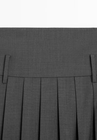 Gray pleated skirt with a textured fabric, featuring decorative pleats and belt loops at the waistband.