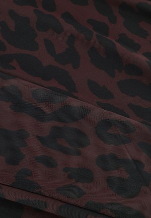 Roter und schwarzer Leopardenmusterstoff mit strukturierter Oberfläche und abstraktem Fleckenmuster, in Falten drapiert.