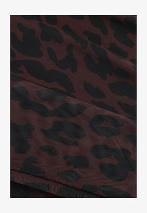 Rood en zwart luipaardprint stof met een gestructureerd oppervlak en abstracte vlekkenpatroon, in plooien gedrapeerd.