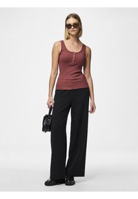 Ribbed maroon tank top with three buttons, paired with black wide-leg trousers. Black handbag and round sunglasses complete the look.