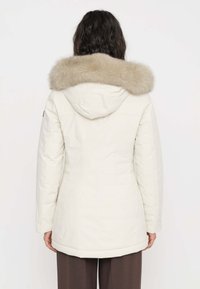 Parka color beige chiaro con colletto in ecopelliccia removibile, dotata di cappuccio e tasche laterali; tessuto liscio con vestibilità sartoriale.