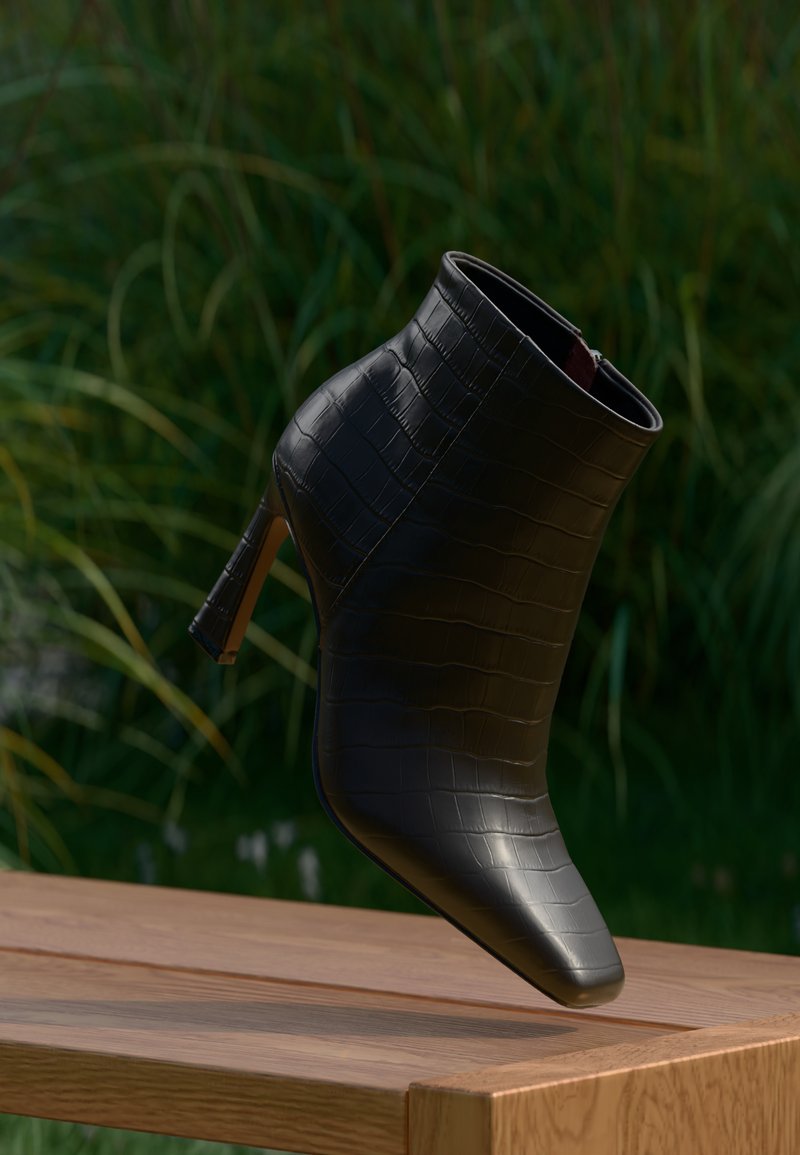 Bottine noire en cuir synthétique texturé avec un motif crocodile, présentant un bout pointu et un talon mince et haut.