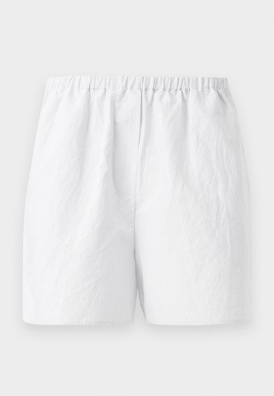 Baltos šortai su elastine juosta, pagaminti iš tekstūruoto audinio ir laisvo kirpimo. Paprastas dizainas, be raštų ar papuošimų.
