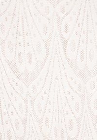 Lace stof i lys creme med et delikat design med gentagne tåreformede mønstre og fin, detaljeret strikketekstur.