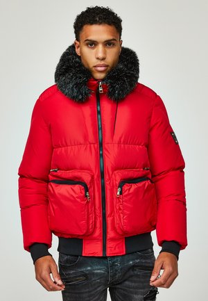 Chaqueta acolchada roja con cuello de piel sintética negra, cierre frontal con cremallera y dos bolsillos con cremallera. Incluye puños y dobladillo de canalé negros.