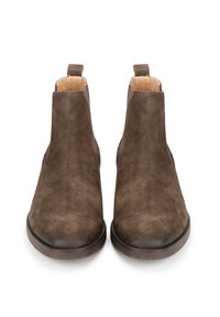 Botas de tobillo de ante marrón con una textura suave, tacón bajo y paneles laterales elásticos. Presentan una lengüeta en la parte posterior para facilitar su uso.