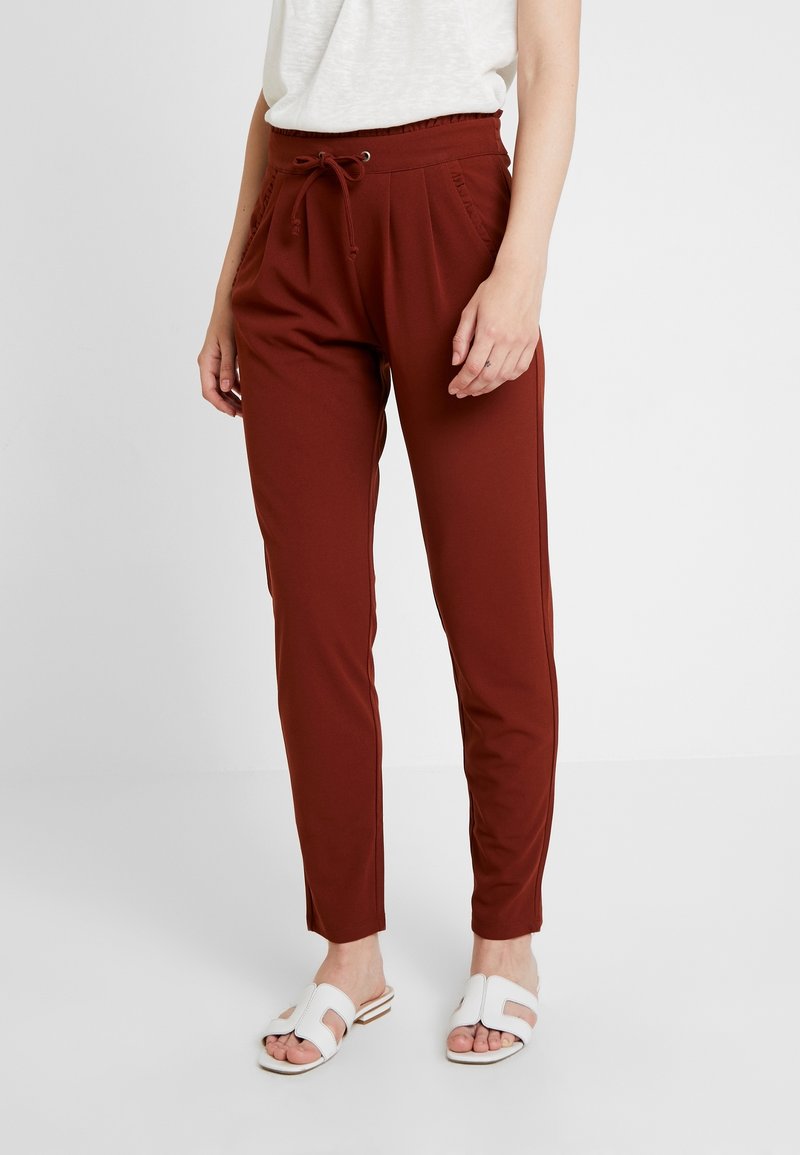 Pantalons jogger bordeaux avec taille à cordon, jambes fuselées et poches latérales, fabriqués en tissu doux et extensible pour le confort.