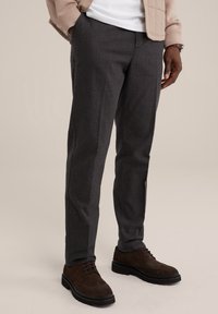 Grå texturerade byxor har en skräddarsydd passform, sidofickor och en slät yta. De är matchade med bruna mockaskor med snörning.