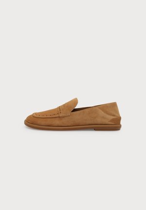 Mocassin en daim beige clair avec une semelle en caoutchouc basse, des coutures apparentes et un détail fente à penny classique, présenté en profil gauche sur fond blanc.