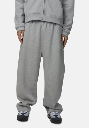 Pantaloni della tuta grigi con fascia elastica in vita, vestibilità ampia e tasche laterali. Realizzati in tessuto morbido, con dettagli di cuciture discrete.