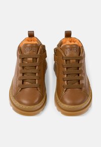 Chaussures d'enfant en cuir marron avec doublure orange, bout rond, à lacets et fermeture éclair, semelle en caoutchouc et accents cousus.