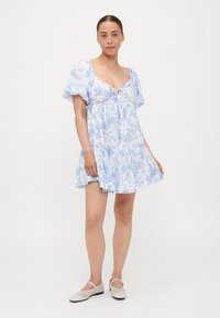 Hele sinine lillemusteriga kleit, millel on paisutatud varrukad, sidumisdetail ees ja laienev hem. Pehme kangas, millel on õrn, korduv lillemuster.