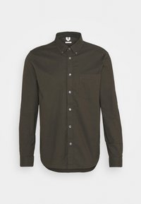 Camicia button-up verde scuro con maniche lunghe, colletto, tasca frontale e orlo curvo. Realizzata in cotone con bottoni blu.