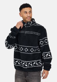 Pullover in pile nero con zip a un quarto, caratterizzato da motivi geometrici bianchi e una superficie texture. Cordoncino regolabile all'orlo.