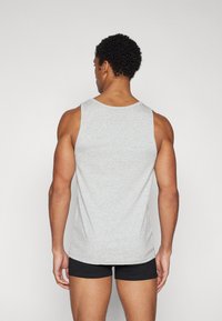 Graues ärmelloses Tanktop aus einem weichen, leichten Material mit einem schlichten Design. Der Rücken ist glatt und hat keine sichtbaren Muster oder Akzente.