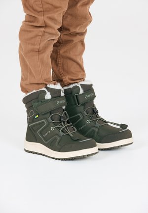 Dunkelgrüne, wasserdichte Stiefel mit einem weißen Kunstfellfutter, Schnürung und Klettverschluss, strukturiertem Gummisohle und geometrischen Designdetails.