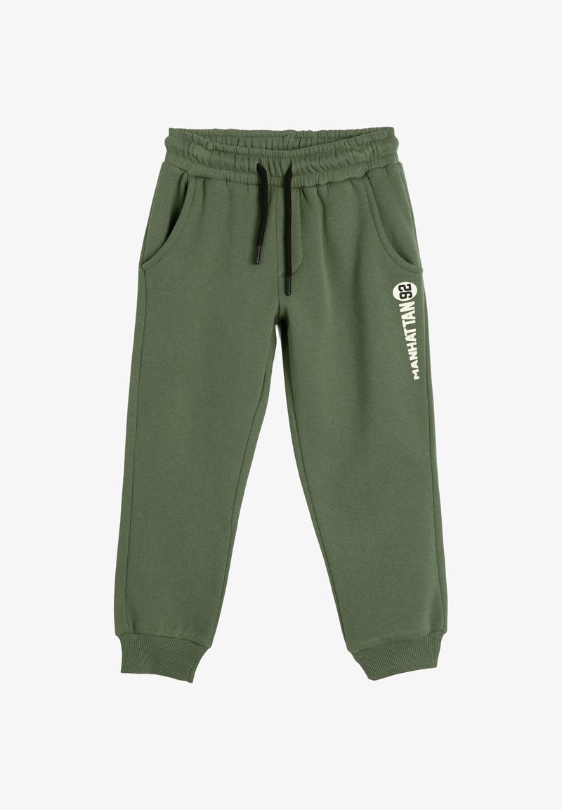 Grønne sweatpants lavet af blød stof, med elastisk talje og sort snor, sidelommer og et grafisk design på det ene ben.