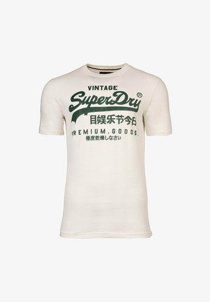 Crème-kleurige t-shirt met korte mouwen van katoen, met groene bedrukte tekst en logo's, waaronder "Vintage" en "SuperDry", met minimale details.