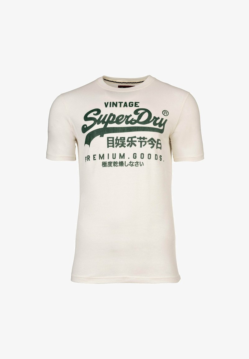 Camiseta de algodón de manga corta en color crema, con texto y logotipos impresos en verde, incluyendo "Vintage" y "SuperDry", con un detalle mínimo.