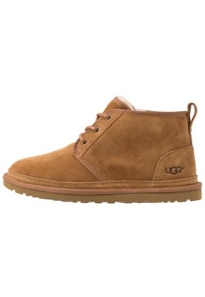 Tan suede ankle boots with lace-up design, round toe, and rubber sole. Features soft lining and a logo on the heel.