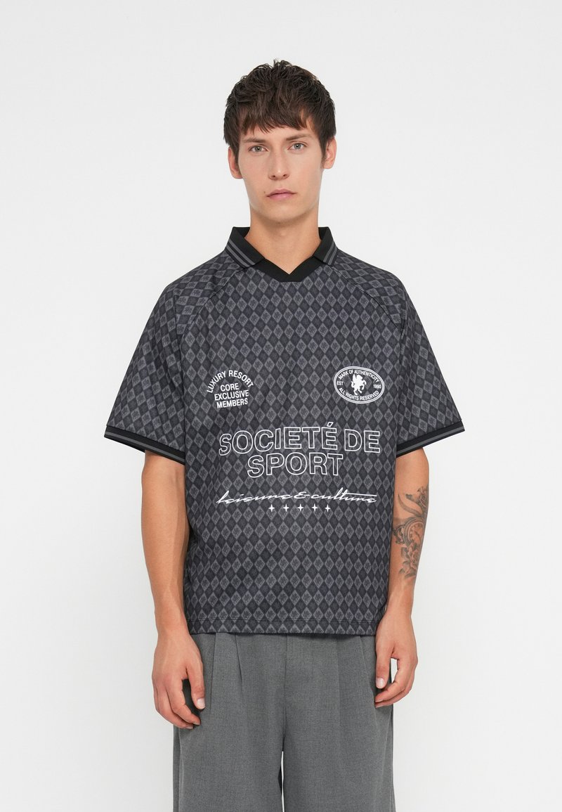 Svartmønstret kortermet skjorte med krage-design. Har diamantermønster, tekstlogoer og kontrasterende svart halslinning.