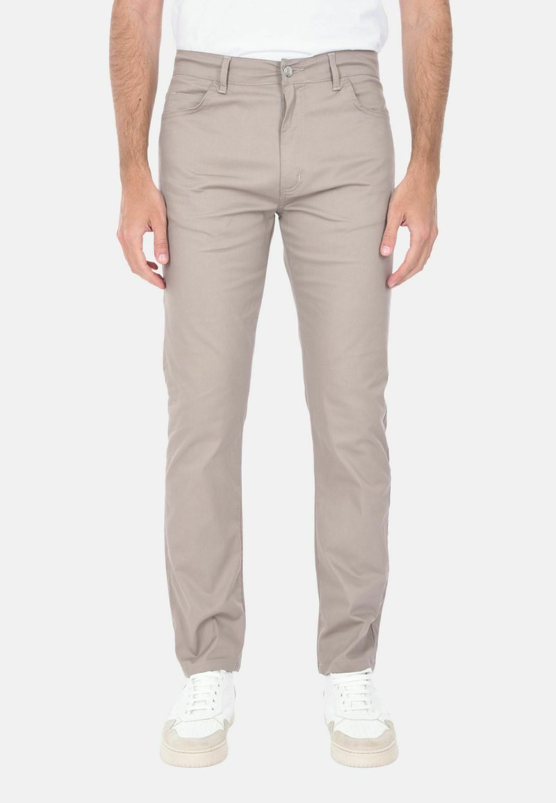 Pantaloni beige slim-fit realizzati in tessuto di cotone elasticizzato, caratterizzati da un classico design a cinque tasche, passanti per cintura e chiusura con zip e bottone.
