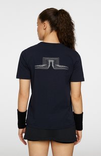 Marineblå t-shirt med kort ärm som har en geometrisk vit design på baksidan. Gjord av bomull, har den en avslappnad passform och rundad halsringning.