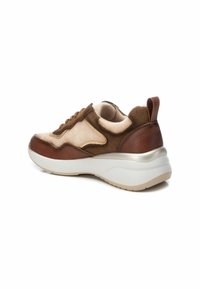 Zapatillas marrones y beige elaboradas con materiales de ante y cuero, una suela blanca gruesa y un cuello acolchado con una lengüeta.