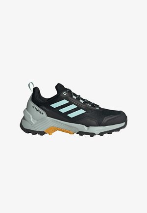 Schwarzer Trailrunning-Schuh mit atmungsaktivem Obermaterial, hellblauen Akzenten, einer strukturierten Außensohle und einer gedämpften Zwischensohle mit orangefarbenen Details.