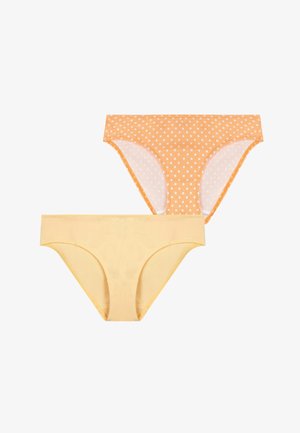 Deux culottes bikini en coton pour femmes, l'une jaune clair uni et l'autre orange à pois blancs, posées à plat sur un fond blanc.