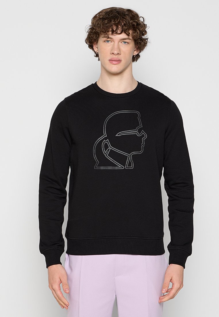 Sweatshirt noir en tissu mélange de coton avec un contour brodé d'un profil à l'avant. Encolure ronde et poignets côtelés.