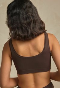 Pruun bralette sujuva, elastse materjaliga. Omab laiad rihmad ja ruudukujulist seljaosa, mis tagab sujuva ja mugava istuvuse.