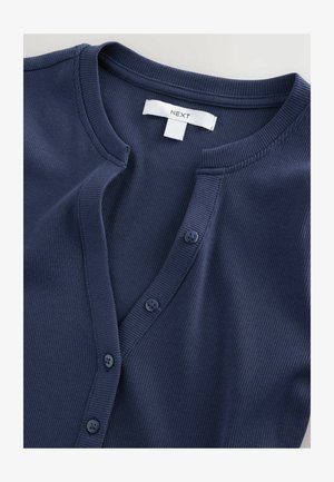 Cárdigan de canalé azul marino con escote en V y cinco botones a juego. Etiqueta con la marca "NEXT". Tejido texturizado; diseño liso y ajustado.