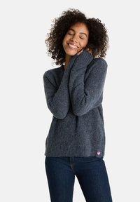 Grau gestrickter Pullover mit lockerem Schnitt, gerippter Textur, weiter V-Ausschnitt und langen Ärmeln, mit einem kleinen rosafarbenen Herz-Logo am Saum.