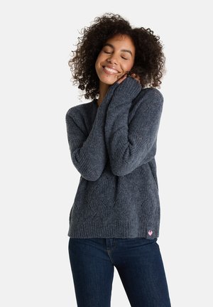 Grau gestrickter Pullover mit lockerem Schnitt, gerippter Textur, weiter V-Ausschnitt und langen Ärmeln, mit einem kleinen rosafarbenen Herz-Logo am Saum.