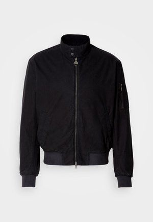 Casaco bomber preto com fecho de correr, punhos em ribanas e gola alta. Inclui bolsos laterais e um bolso com fecho de correr na manga.