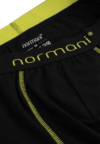 Schwarze Baumwoll-Boxershorts mit einem gelben elastischen Bund und Nähten. Der Markenname "normani" ist gut sichtbar auf dem Bund platziert.