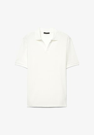 Polo bianca a maniche corte con linee verticali testurizzate e collo aperto, mostrata distesa su uno sfondo bianco.