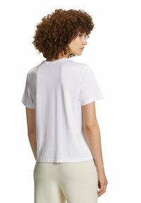 T-shirt bianco in cotone a maniche corte, con scollo rotondo e vestibilità rilassata. Tessuto liscio senza motivi o dettagli visibili.