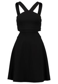 Svart ärmlös klänning med korsande band, åtsittande liv och utsvängd kjol. Tillverkad av ett slätt tyg i en enhetlig färg utan mönster.