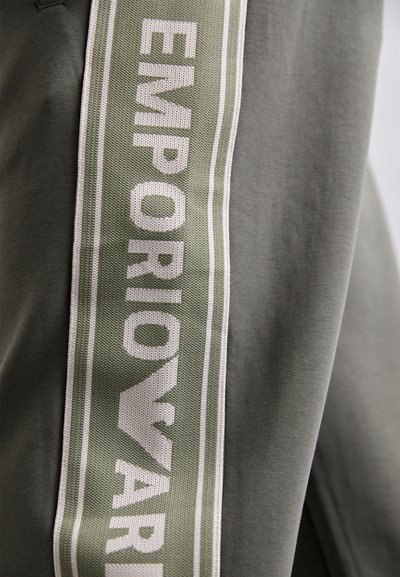 Sivá látka so širokým zeleným pruhom, na ktorom sú biele písmena píšuce "EMPORIO ARMANI." Mäkká textúra a športový dizajn.