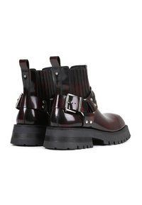 Bottines en cuir verni noir et bordeaux avec des panneaux latéraux élastiques, un détail de sangle à boucle et des semelles en caoutchouc noir robustes.