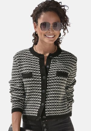Zwart-witte gebreide cardigan met een textuurpatroon, ronde halslijn, knoopsluiting en twee voorzakken.