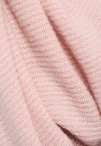 Helles rosa gestricktes Gewebe mit einer weichen, flauschigen Textur. Es hat ein geripptes Design und subtile Variationen in Tiefe und Dicke.